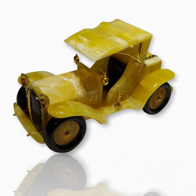 Geltonojo gintaro klasikinis automobilis su uždaru stogeliu