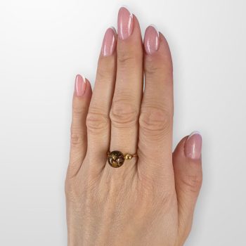 Amber ring in the shape of an ideal sphere, transparent with earth residues