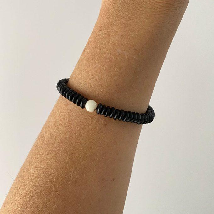 Stylish black amber disc bracelet with white amber detail in the shape of an ideal sphere