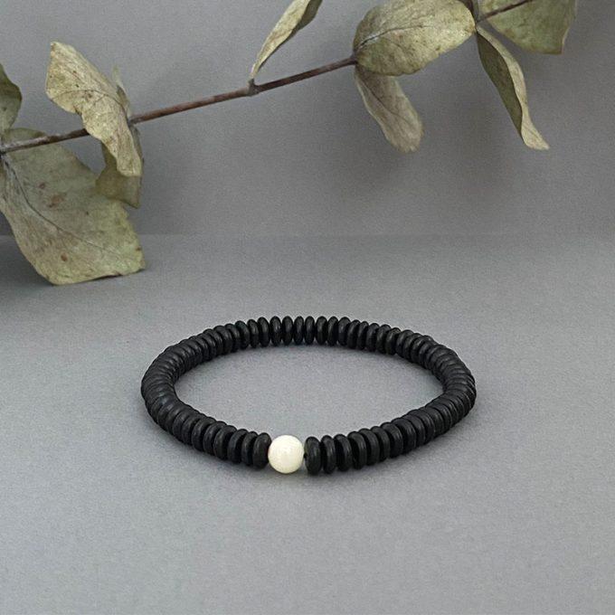 Stylish black amber disc bracelet with white amber detail in the shape of an ideal sphere