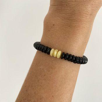 Stylish bracelet in black shiny amber discs with three yellowish central discs