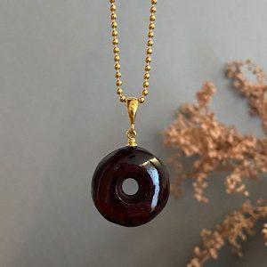 Dailus apvalus tamsios vyšnios spalvos gintaro amuletas