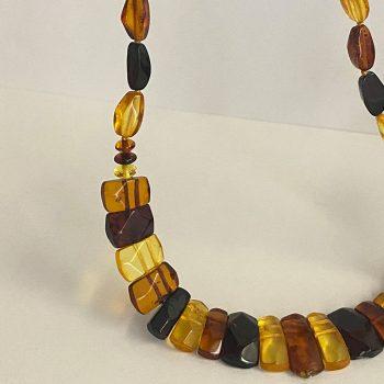 Expressive collage of multicoloured amber pebbles cut into abstract shapes