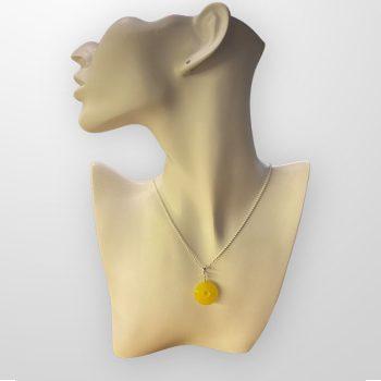 Stylish round amber amulet in yellow shades