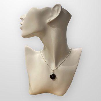 Stylish round amber amulet in dark cherry colour