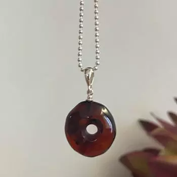 Stilingas apvalus tamsios vyšnios spalvos gintaro amuletas