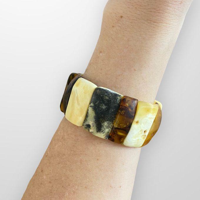 Luxury bracelet of multicoloured amber pieces with bark