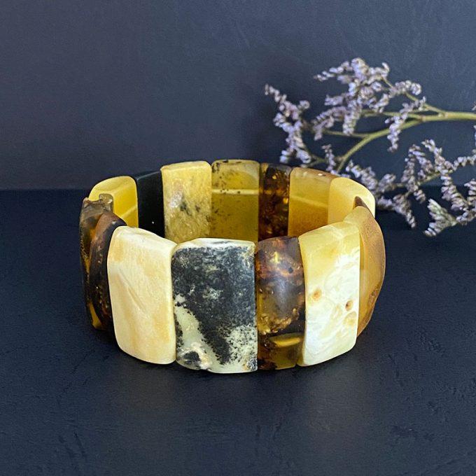 Luxury bracelet of multicoloured amber pieces with bark