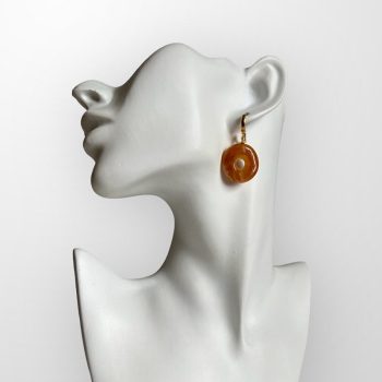 Distinctive earrings in irregular circle shape with a hole in yellow amber with bark remnants