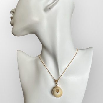 Expressive ball-shaped elk antler neck pendant with inlaid amber detail