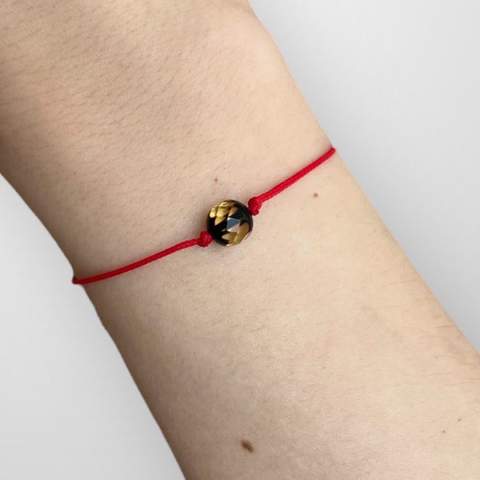 Stylish adjustable lucky bracelet with green faceted amber ball