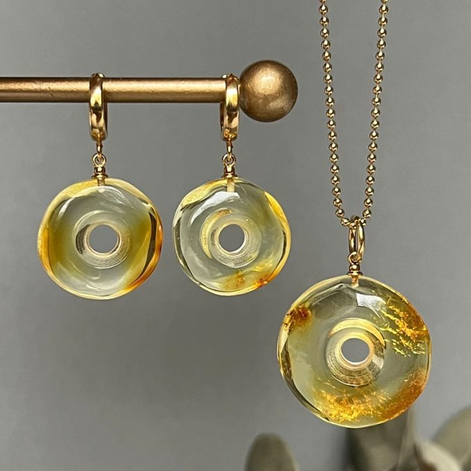 Fine set of clear amber earrings and pendant in the shape of an amulet