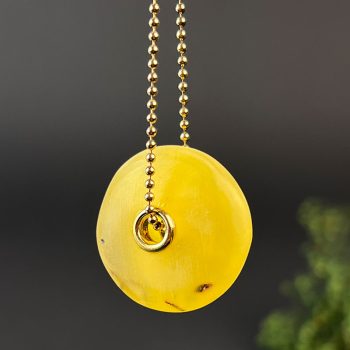 Chic yellow matt amber neck pendant with decorated hole in the centre