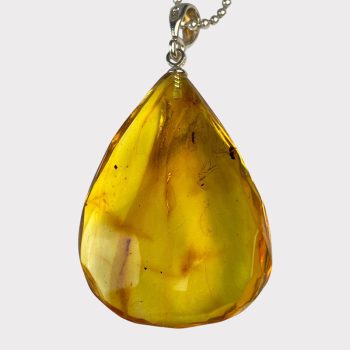 Delicate drop-shaped clear amber pendant with inlays