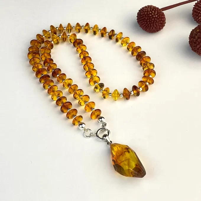 Fine honey coloured amber necklace with amber pendant with inlay