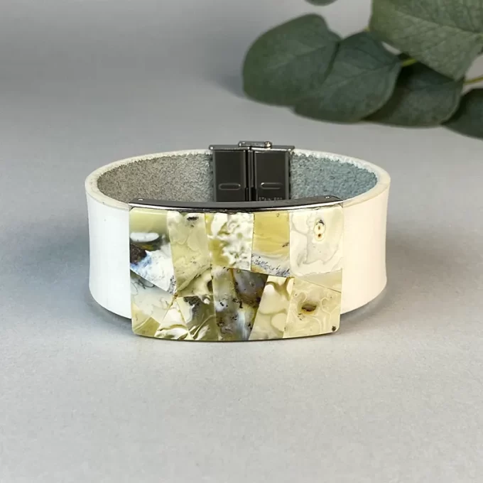 Trendy white leather bracelet with greenish landscape amber detail