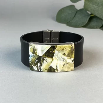 Fashionable black leather bracelet with greenish amber detail