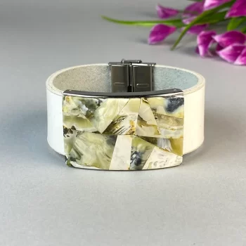 Stylish white leather bracelet with greenish landscape amber detail