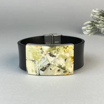 Stylish black leather bracelet with greenish landscape amber detail