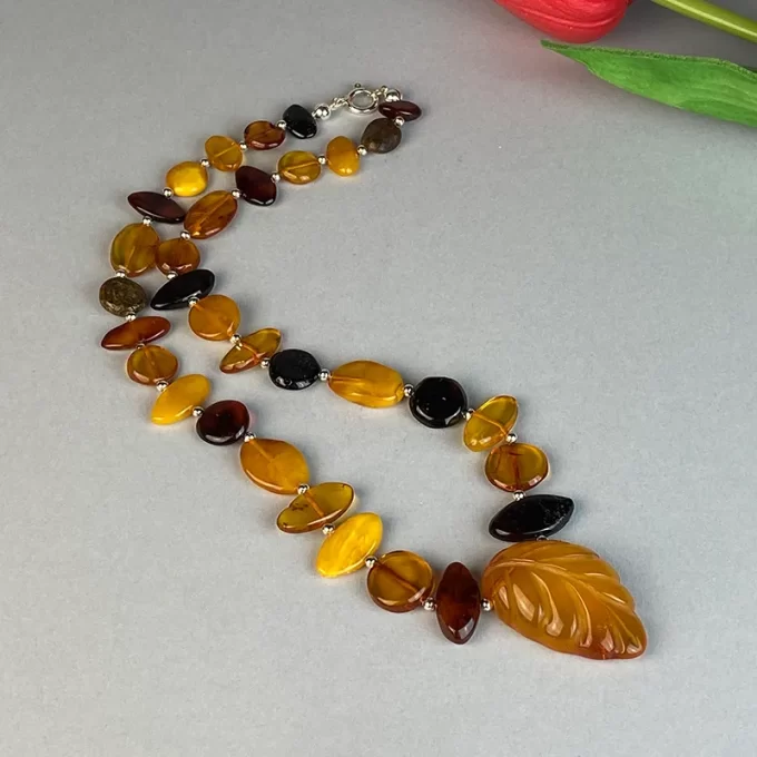 Fine multicoloured amber pebble necklace with engraved pendant