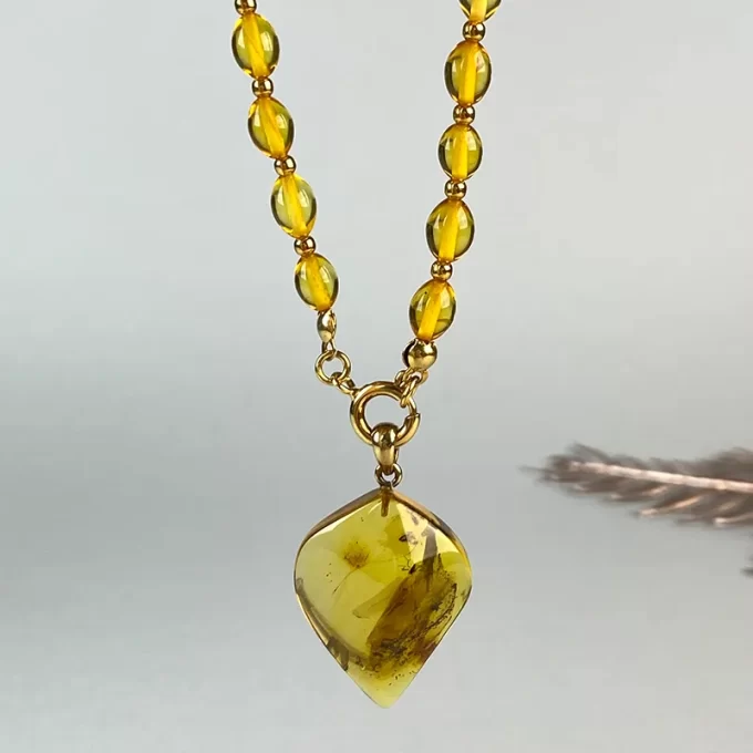Fine clear amber necklace with clear pendant with inlay