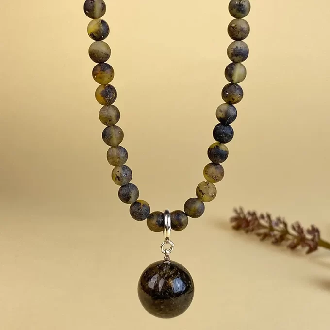 Stylish necklace with pendant in matt dark amber beads