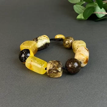 Beautiful bracelet with light and dark speckled amber details in various shapes
