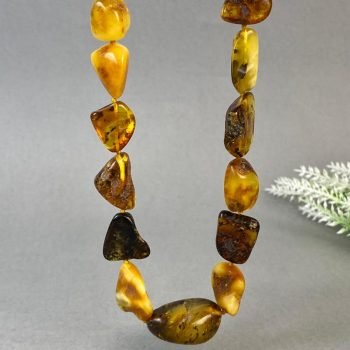 Modernus įvairių formų ir spalvų neblizgus gintaro vėrinys