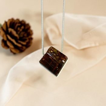 Stilingas ir modernus briedžio rago ir tamsaus graviruoto gintaro pakabukas